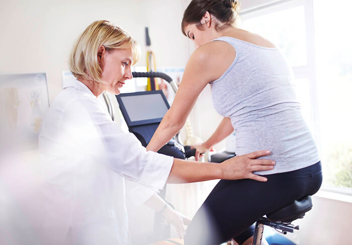 Frau auf Ergometer als Teil der Vorsorge-Untersuchung