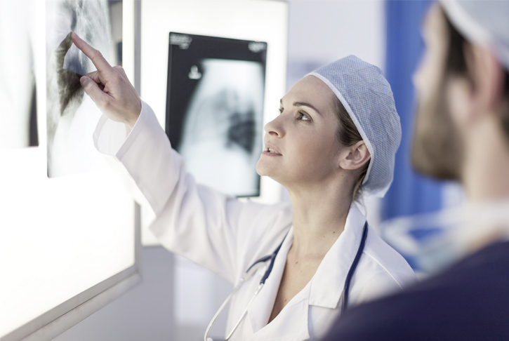 Ärztin und Arzt besprechen Röntgenbild